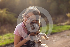 Little girl playing with her Yorkshire Terrier dog in the park