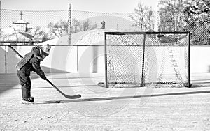 Little girl playing hockey on outdoor rink