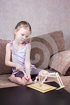 Little girl is playing with hydraulic model