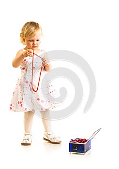 Little girl playing with jewelry box on a white background.