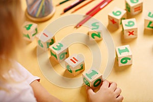 Little girl playing with kid math cubes
