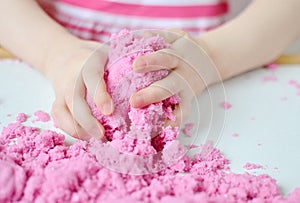 Little Girl Playing with Pink Kinetic Sand at Home Early Education Preparing for School Development Children Game photo