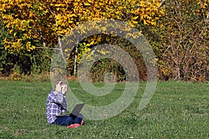 Little girl playing laptop and listening music on headphon