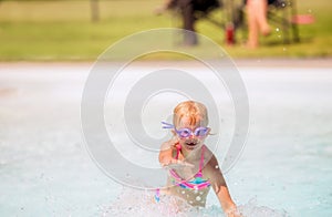 Little girl playing and laughing in a swimming pool