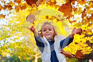 Little girl playing with leaves