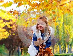 Little girl playing with leaves