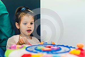little girl playing with little toys in the kindergarten
