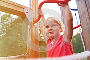 Little girl playing on monkey bars, kids sport