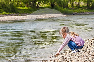 Little girl playing near the river