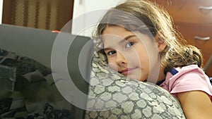 Little girl playing in the notebook online game laptop