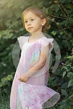 Little girl playing outdoor in nature inside a forest. Education in nature