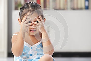 Little girl playing peekaboo