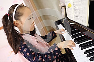 Little girl playing the piano at home