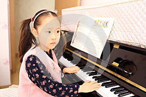 Little girl playing the piano at home