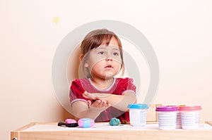 Little girl playing with plasticine