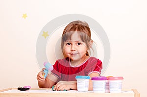 Little girl playing with plasticine