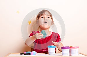 Little girl playing with plasticine