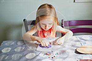Little girl playing with playdough at home, in kindergaten or preschool