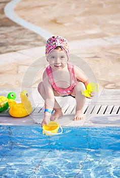Little girl playing at the pool