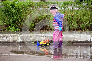 Little girl playing in the puddle