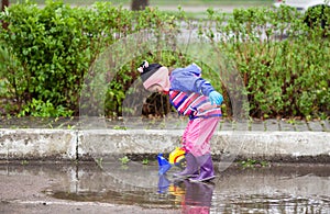 Little girl playing in the puddle