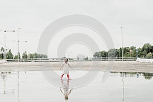 Little girl playing in a puddle, happy. stock photo