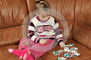 Little Girl Playing With Puzzle Pieces
