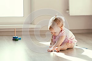 Little girl playing with pyramid on floor