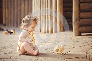 Little girl playing with rabbit in the village. Outdoor. Summer portrait.