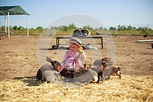 Little girl playing with rabbits on a sunny summer or spring day at sunset.