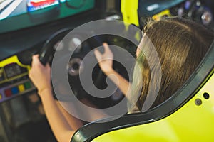 Little girl playing racing simulator game.