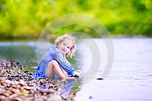 Little girl playing at river shore
