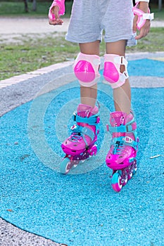 Little girl playing with roller skates