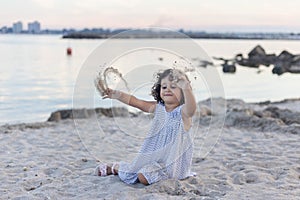 Little Girl playing in the sand at dusk