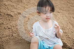Little girl playing on the sand pile