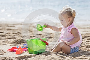 Little girl playing sand toys at the beach