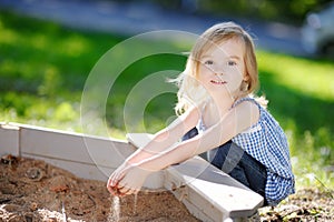 Little girl playing in a sandbox