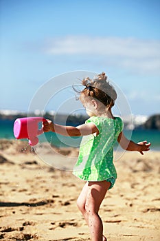 Little girl playing on sandy beach