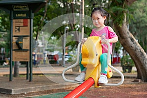 Little girl are playing seesaw in the playground