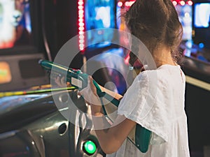 Little girl playing shooter game.