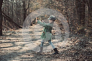 Little girl playing with a slingshot