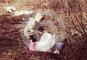 A little girl playing with snow outdoors at winter