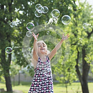 Little girl playing with soap bubbles