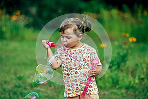 Girl playing with soap bubbles in the Park