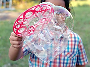 little girl playing soap bubbles in playground