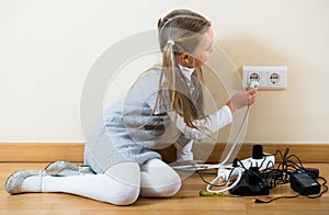 Little girl playing with sockets at home
