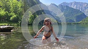 Little girl playing and splashing river water