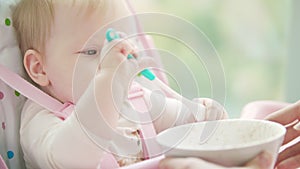 Little girl playing with spoon. Portrait of cute infant eating by herself