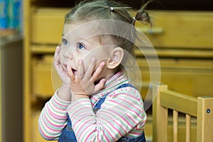 Little girl playing and studying on lessons in kindergarden