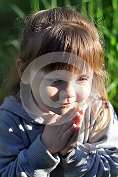 Little girl playing in sunny blooming forest, looking out from grass. Toddler child picking lupine flowers. Kids play outdoors. Su